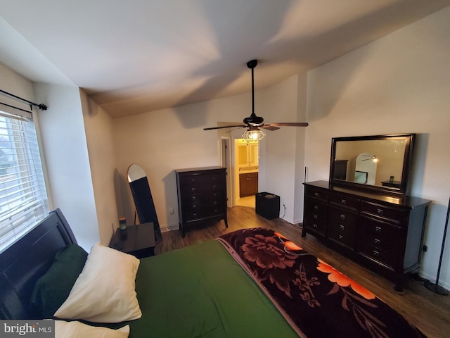 bedroom featuring dark hardwood / wood-style flooring, ensuite bathroom, vaulted ceiling, and ceiling fan