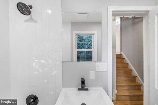 bathroom with tiled shower, hardwood / wood-style flooring, and vanity