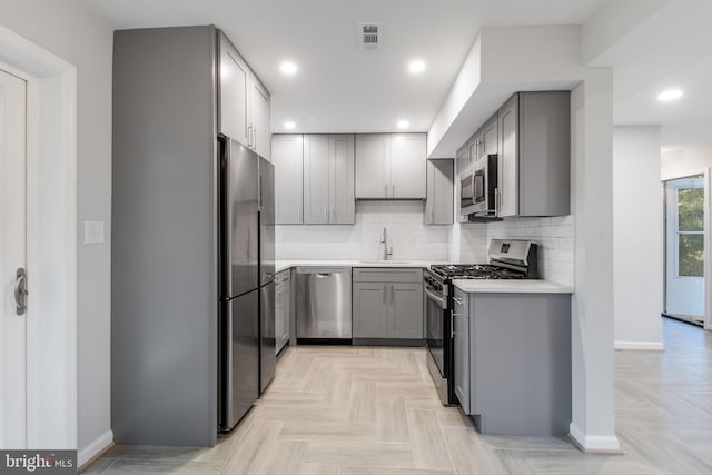 kitchen featuring gray cabinetry, sink, and stainless steel appliances