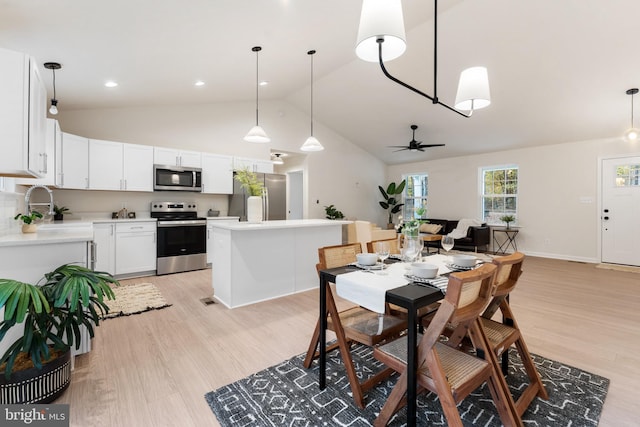 dining room with high vaulted ceiling, recessed lighting, light wood-type flooring, and ceiling fan