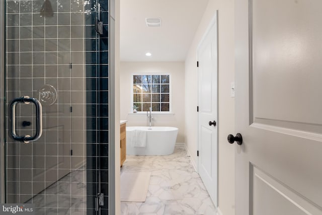 full bath featuring baseboards, a freestanding tub, recessed lighting, marble finish floor, and a stall shower
