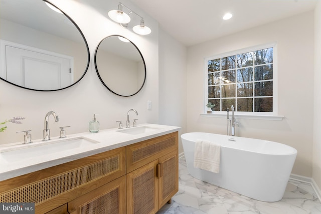 full bathroom with a sink, double vanity, marble finish floor, and a soaking tub