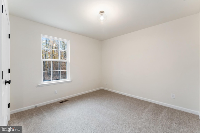 spare room with visible vents, baseboards, and carpet