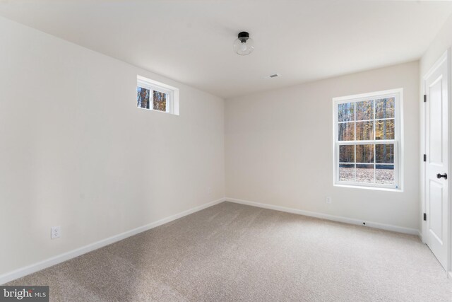 empty room featuring visible vents, baseboards, light colored carpet, and a healthy amount of sunlight