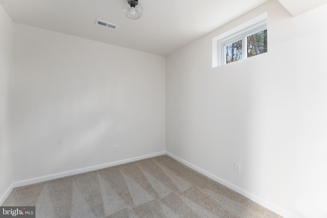 empty room with light carpet, visible vents, and baseboards