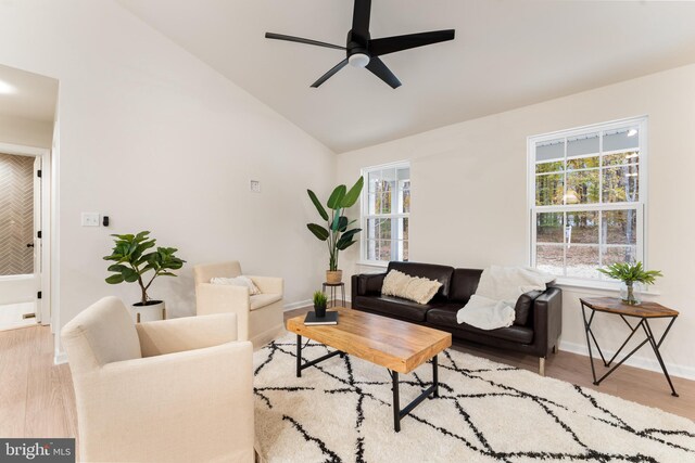 living room with wood finished floors, baseboards, a ceiling fan, and a healthy amount of sunlight