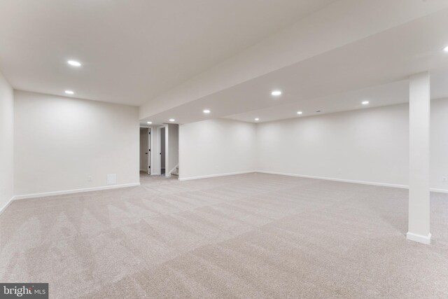 finished below grade area featuring baseboards, recessed lighting, and light carpet
