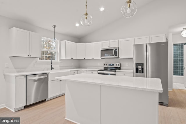 kitchen featuring white cabinets, pendant lighting, stainless steel appliances, and lofted ceiling