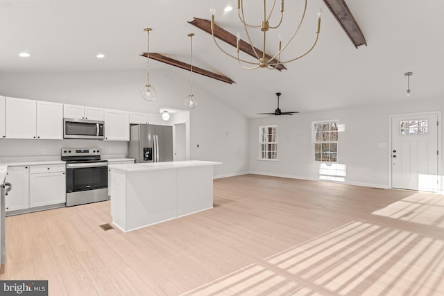 kitchen with beam ceiling, white cabinetry, stainless steel appliances, and light hardwood / wood-style flooring