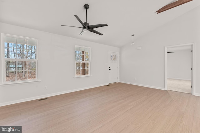 unfurnished living room with ceiling fan, lofted ceiling, a wealth of natural light, and light hardwood / wood-style flooring