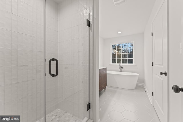 bathroom featuring tile patterned flooring, vanity, and shower with separate bathtub