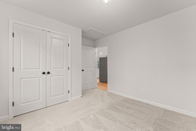 unfurnished bedroom with light carpet and a closet