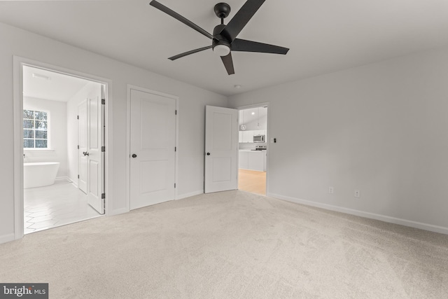 unfurnished bedroom with connected bathroom, ceiling fan, and light colored carpet