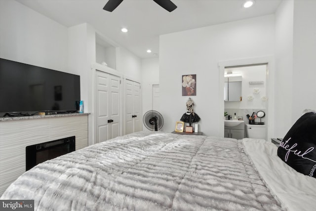 bedroom with a closet, sink, ceiling fan, and ensuite bathroom