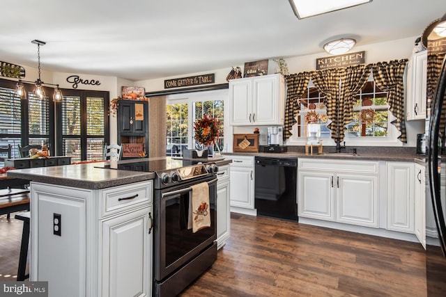 kitchen featuring pendant lighting, dishwasher, dark hardwood / wood-style floors, electric range, and white cabinetry