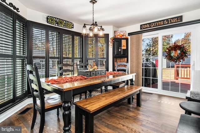 dining space featuring an inviting chandelier and hardwood / wood-style flooring