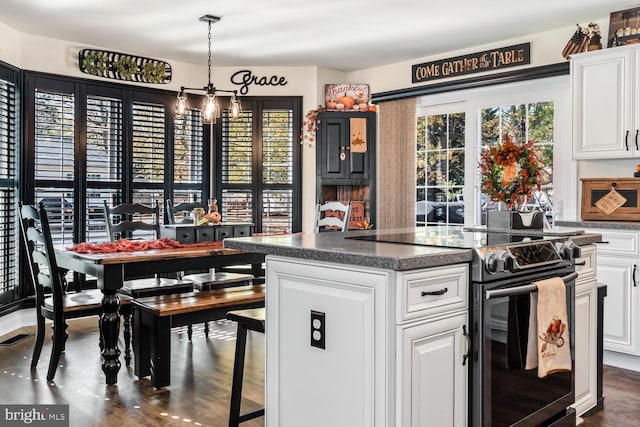 kitchen featuring white cabinets, dark hardwood / wood-style flooring, a center island, and stainless steel electric range