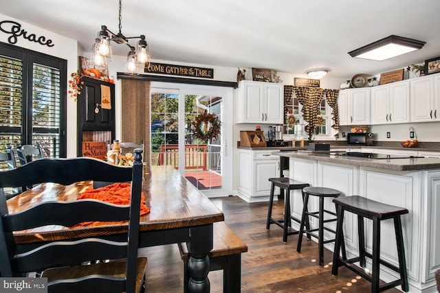 kitchen featuring white cabinets, dark hardwood / wood-style floors, and decorative light fixtures