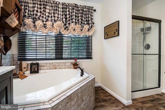 bathroom featuring vanity, plus walk in shower, and hardwood / wood-style floors