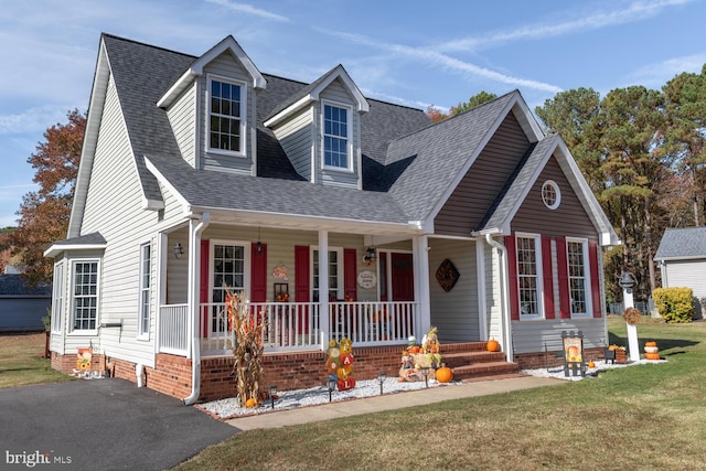 new england style home with a front lawn and covered porch