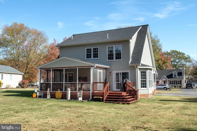 rear view of property with a lawn and a sunroom