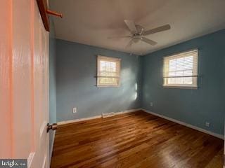 unfurnished room with dark wood-type flooring, ceiling fan, and a healthy amount of sunlight