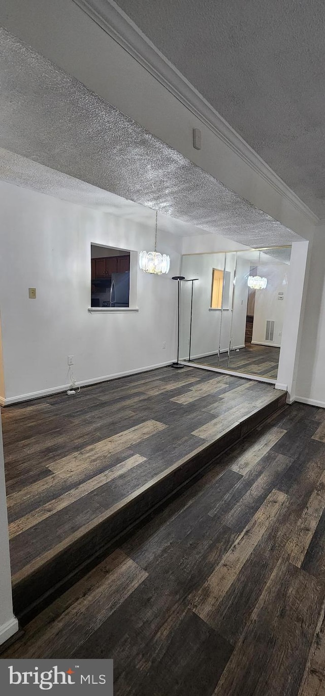 basement with dark hardwood / wood-style flooring, a textured ceiling, and ornamental molding