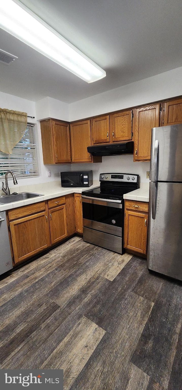 kitchen featuring stainless steel appliances, dark hardwood / wood-style floors, and sink