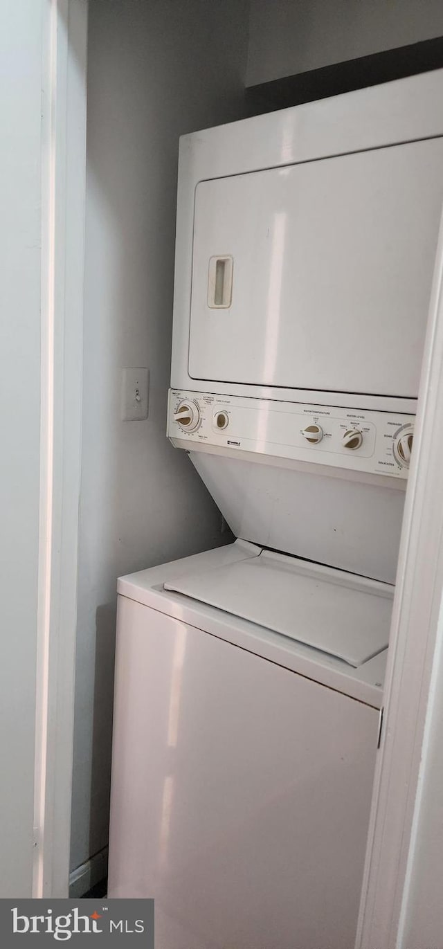 laundry area with stacked washing maching and dryer