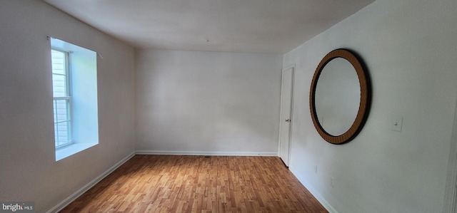 spare room with a wealth of natural light and hardwood / wood-style floors