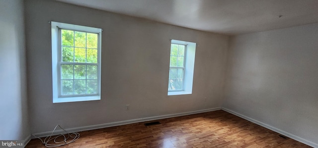 unfurnished room with hardwood / wood-style flooring