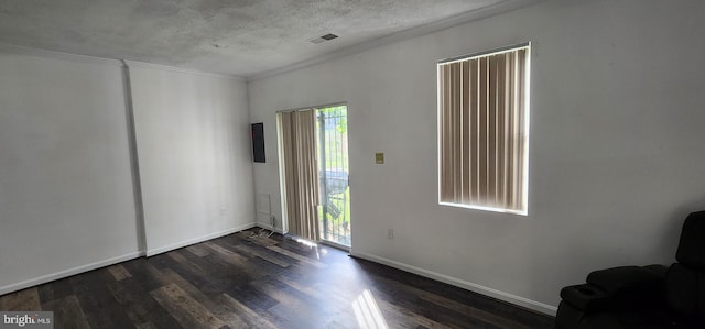 unfurnished room with crown molding, dark hardwood / wood-style flooring, and a textured ceiling