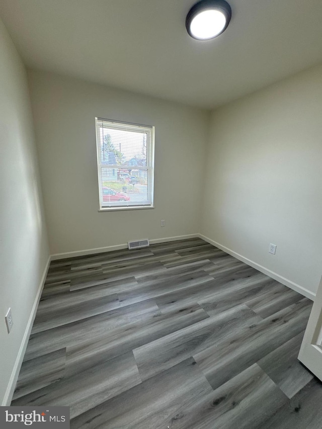 unfurnished room with dark wood-type flooring