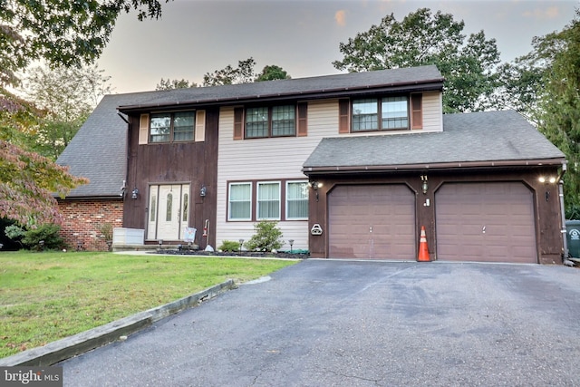 view of front of property featuring aphalt driveway, a front yard, and a shingled roof