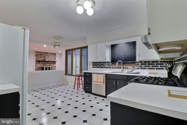 kitchen featuring light countertops, stainless steel dishwasher, gas stove, white cabinetry, and a sink