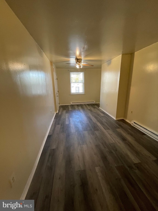 spare room with dark hardwood / wood-style floors, ceiling fan, and a baseboard heating unit