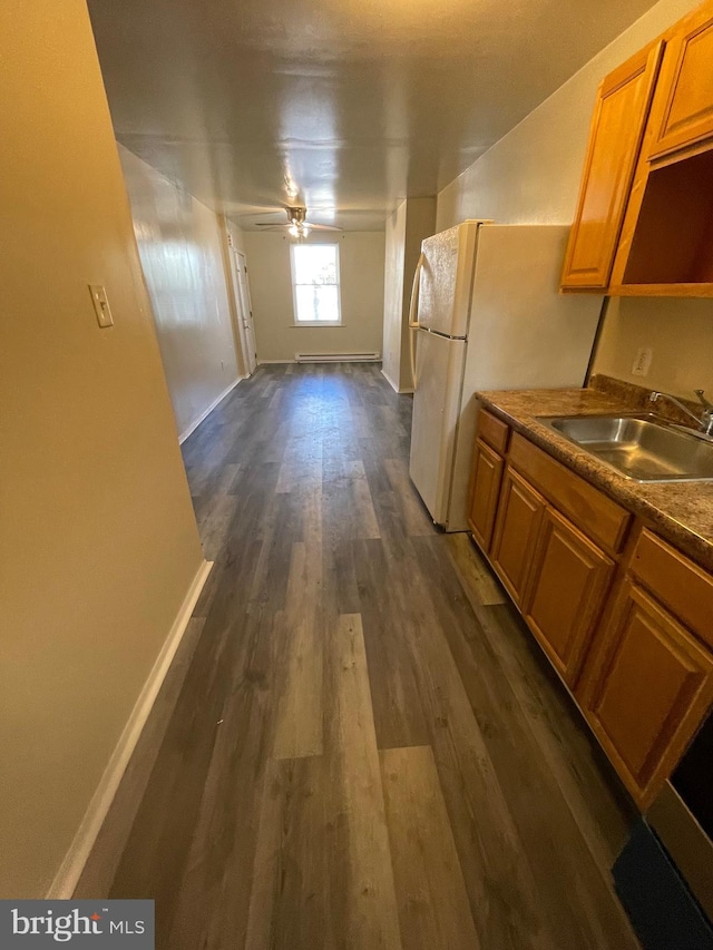 kitchen featuring ceiling fan, white fridge, dark hardwood / wood-style flooring, and sink