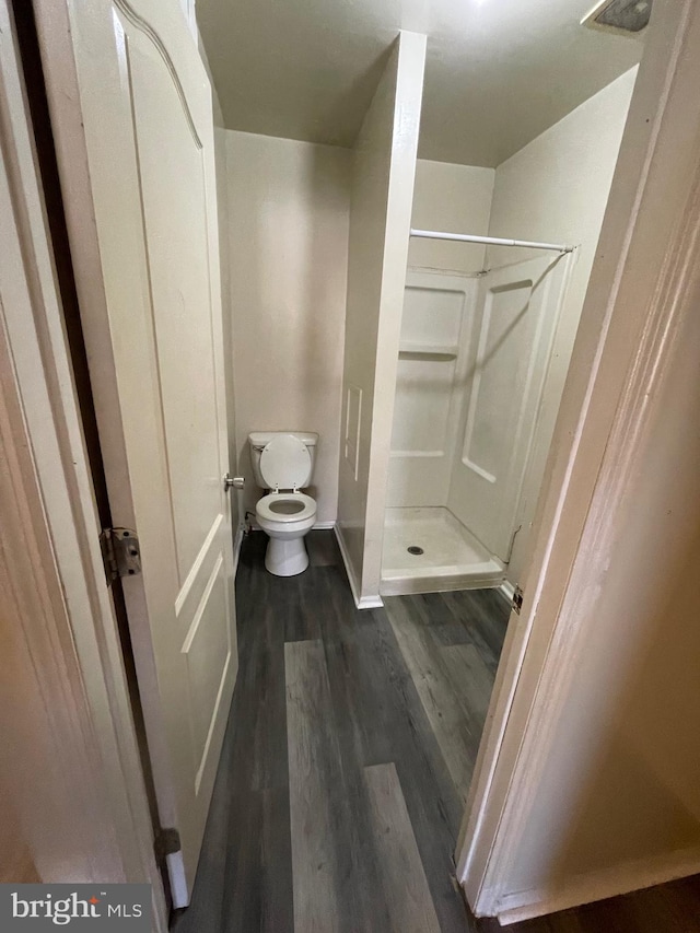 bathroom with walk in shower, toilet, and hardwood / wood-style flooring