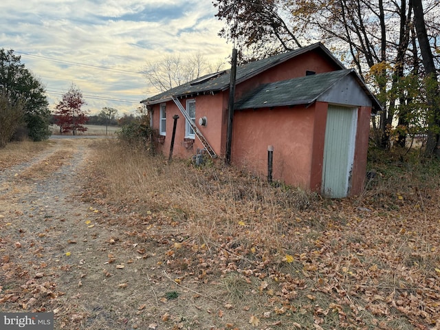 view of side of home with a storage shed