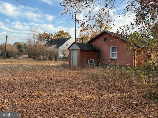 view of side of home with a storage shed