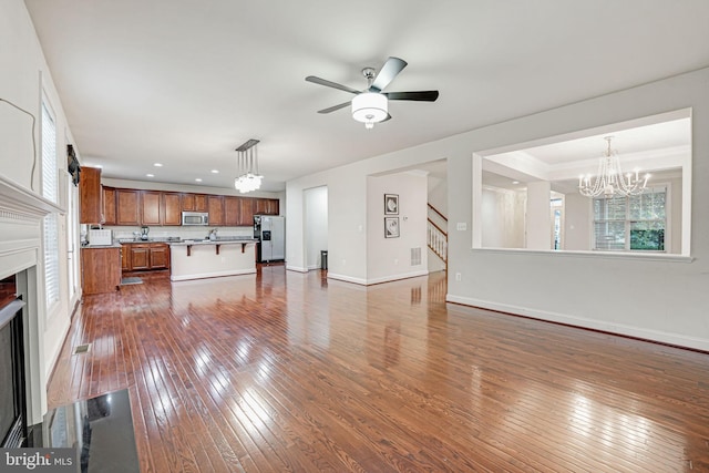 living room featuring dark hardwood / wood-style flooring and ceiling fan with notable chandelier