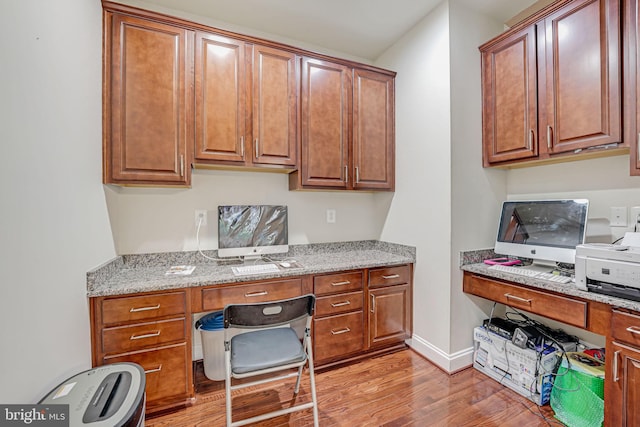 office area featuring built in desk and light hardwood / wood-style floors