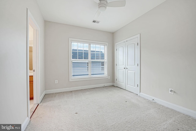 unfurnished bedroom with ceiling fan, a closet, and light carpet