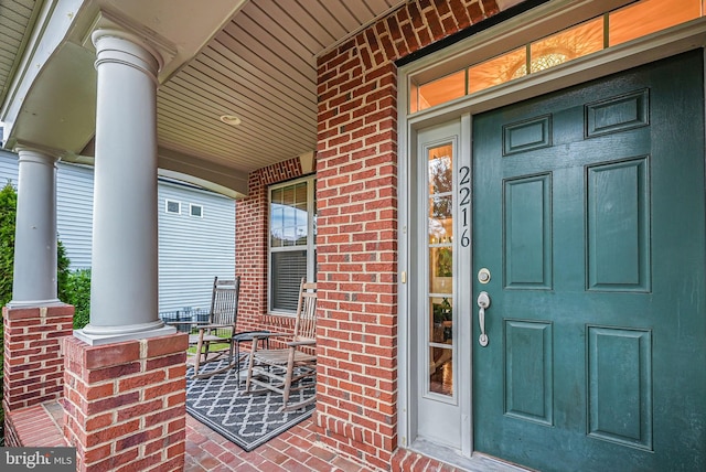 view of exterior entry featuring covered porch