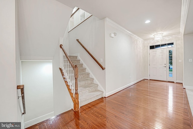 foyer entrance featuring crown molding and hardwood / wood-style floors