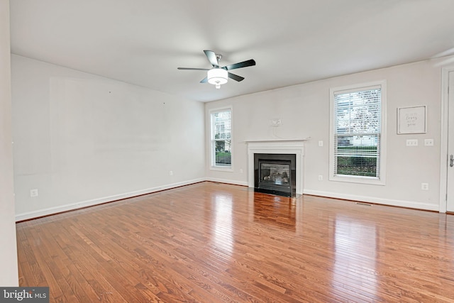 2216 Turnbuckle Ln, Woodbridge, VA 22191 - unfurnished living room with wood finished floors, ceiling fan, a fireplace with flush hearth, and baseboards