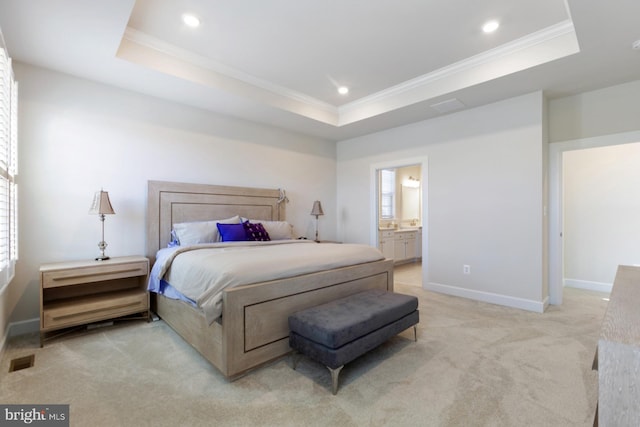 carpeted bedroom featuring ensuite bath, multiple windows, and a raised ceiling