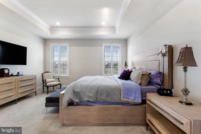 carpeted bedroom with crown molding and a tray ceiling