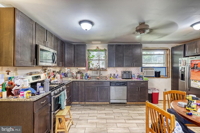 kitchen featuring dark brown cabinetry, sink, appliances with stainless steel finishes, ceiling fan, and light wood-type flooring