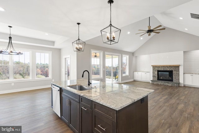 kitchen featuring sink, stainless steel dishwasher, ceiling fan, a fireplace, and decorative light fixtures